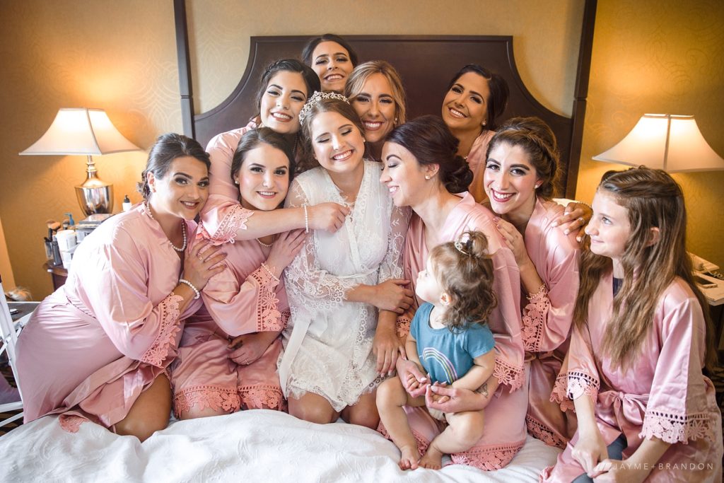 bride and bridesmaids in matching robes hugging